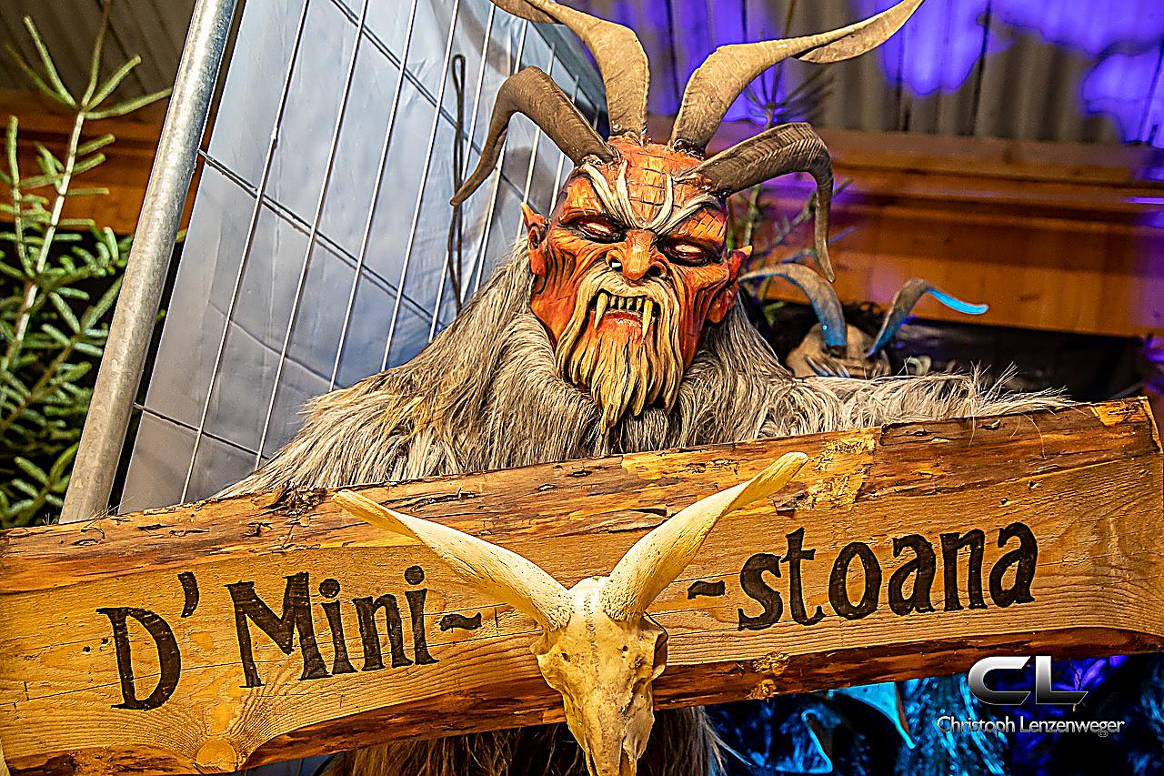 Krampus mit Schild wo oben steht D'Ministoana